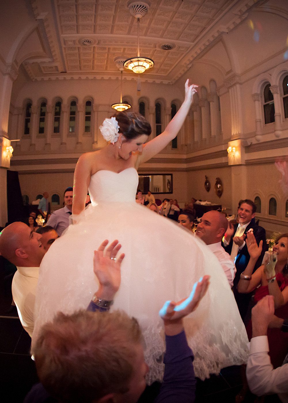 Bride held up on shoulders of guests on the dance floor at her wedding at The Tea Room, QVB, Sydney