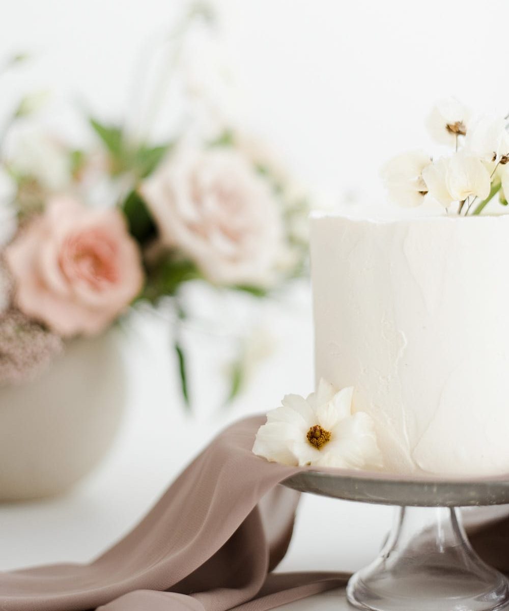 Wedding cake on table with vase of flowers